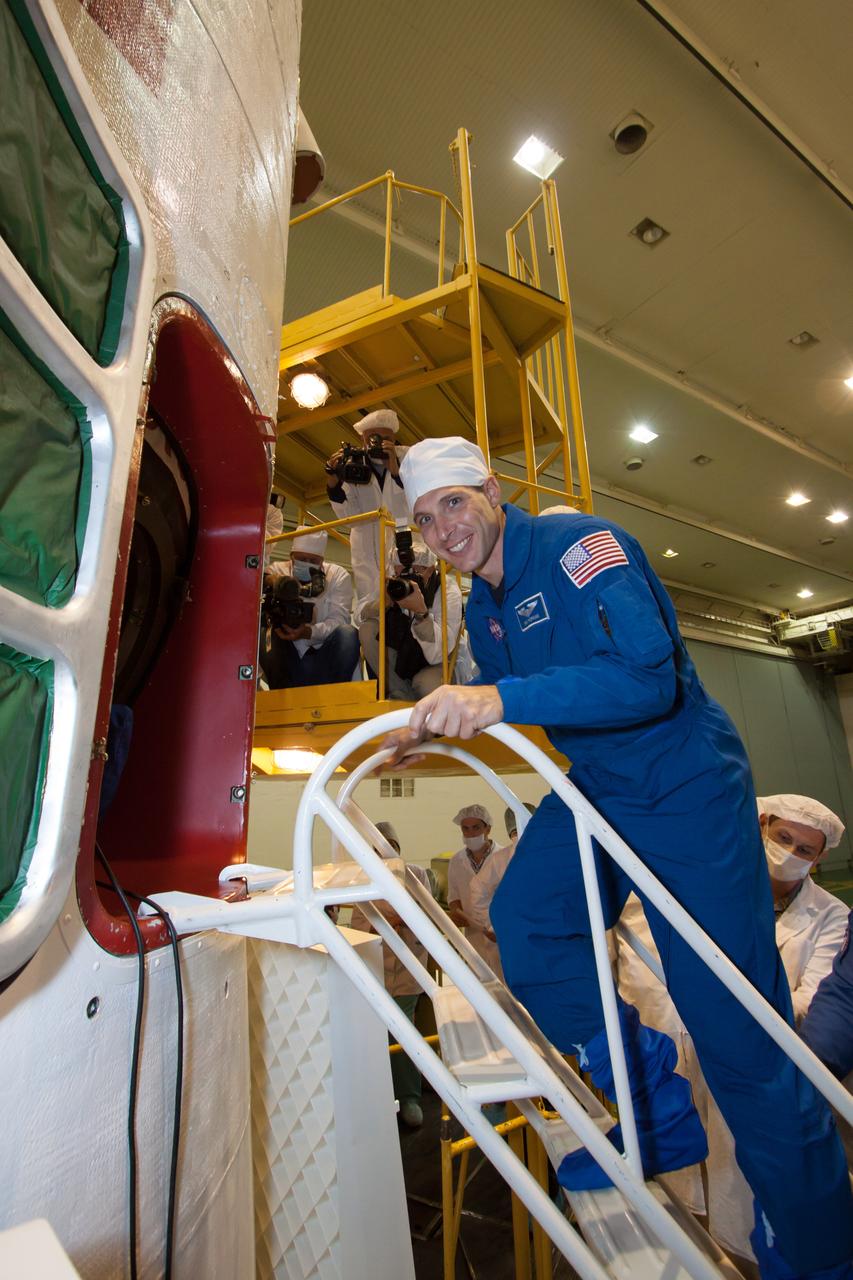 In the Integration Facility at the Baikonur Cosmodrome in Kazakhstan, Expedition 37/38 Flight Engineer Michael Hopkins of NASA flashes a smile as he boards the Soyuz TMA-10M spacecraft Sept. 20. Hopkins and his crewmates, Soyuz Commander Oleg Kotov and Flight Engineer Sergey Ryazanskiy completed a final “fit check” dress rehearsal of procedures leading to their launch Sept. 26, Kazakh time, from Baikonur to begin a five and a half month mission on the International Space Station.  NASA/Victor Zelentsov 