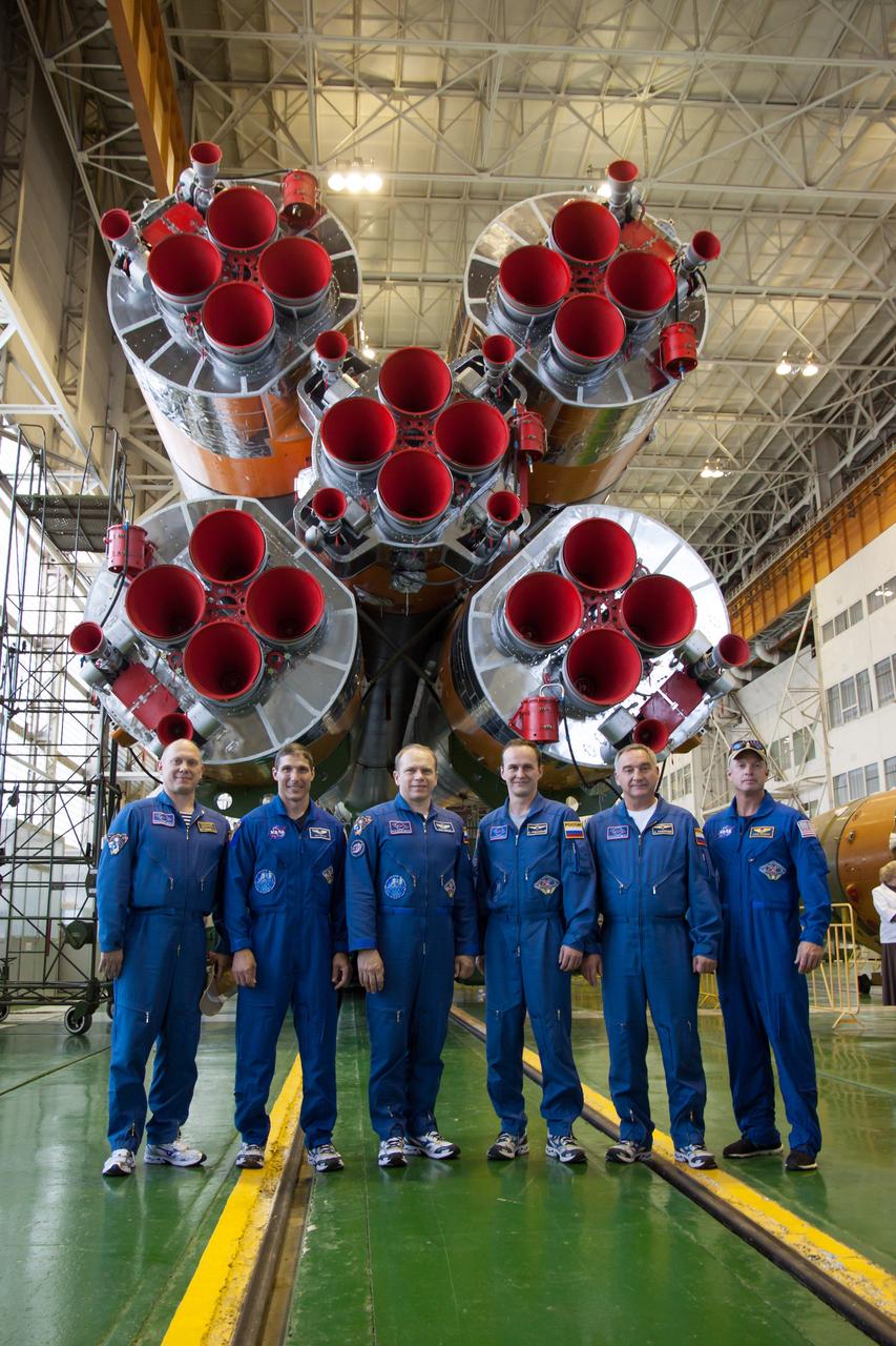 The prime and backup Expedition 37/38 crewmembers pose for pictures in front of the first stage engines of the Soyuz booster rocket in the Integration Facility at the Baikonur Cosmodrome in Kazakhstan Sept. 20. From left to right are backup Flight Engineer Oleg Artemyev, prime Flight Engineer Michael Hopkins of NASA, prime Soyuz Commander Oleg Kotov, prime Flight Engineer Sergey Ryazanskiy, backup So6yuz Commander Alexander Skvortsov and backup Flight Engineer Steve Swanson of NASA. Hopkins, Kotov and Ryazanskiy completed a final “fit check” inspection of their Soyuz TMA-10M spacecraft, preparing for launch Sept. 26, Kazakh time, to begin a five and a half month mission on the International Space Station.  NASA/Victor Zelentsov 