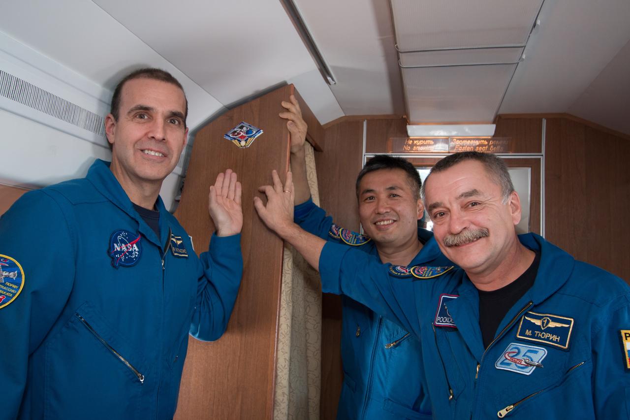 Aboard a Gagarin Cosmonaut Training Center aircraft, Expedition 38/39 Flight Engineer Rick Mastracchio of NASA (left), Flight Engineer Koichi Wakata of the Japan Aerospace Exploration Agency (center) and Soyuz Commander Mikhail Tyurin affix a sticker bearing their mission’s insignia to the cabin’s wall October 26 as they flew from their training base in Star City, Russia to their launch site at the Baikonur Cosmodrome in Kazakhstan for final pre-launch preparations. Mastracchio, Wakata and Tyurin will launch Nov. 7, Kazakh time, in the Soyuz TMA-11M spacecraft from Baikonur to begin a six-month mission on the International Space Station. NASA/Victor Zelentsov