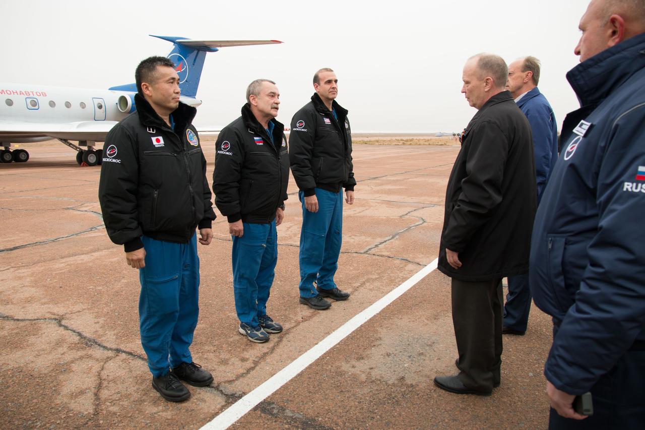 Expedition 38/39 Flight Engineer Koichi Wakata of the Japan Aerospace Exploration Agency (left), Soyuz Commander Mikhail Tyurin (center) and Flight Engineer Rick Mastracchio of NASA (right) greet Russian space officials on the tarmac at Baikonur, Kazakhstan October 26 after they arrived on a flight from their training base in Star City, Russia for final pre-launch preparations. Mastracchio, Wakata and Tyurin will launch Nov. 7, Kazakh time, in the Soyuz TMA-11M spacecraft from Baikonur to begin a six-month mission on the International Space Station.  NASA/Victor Zelentsov 