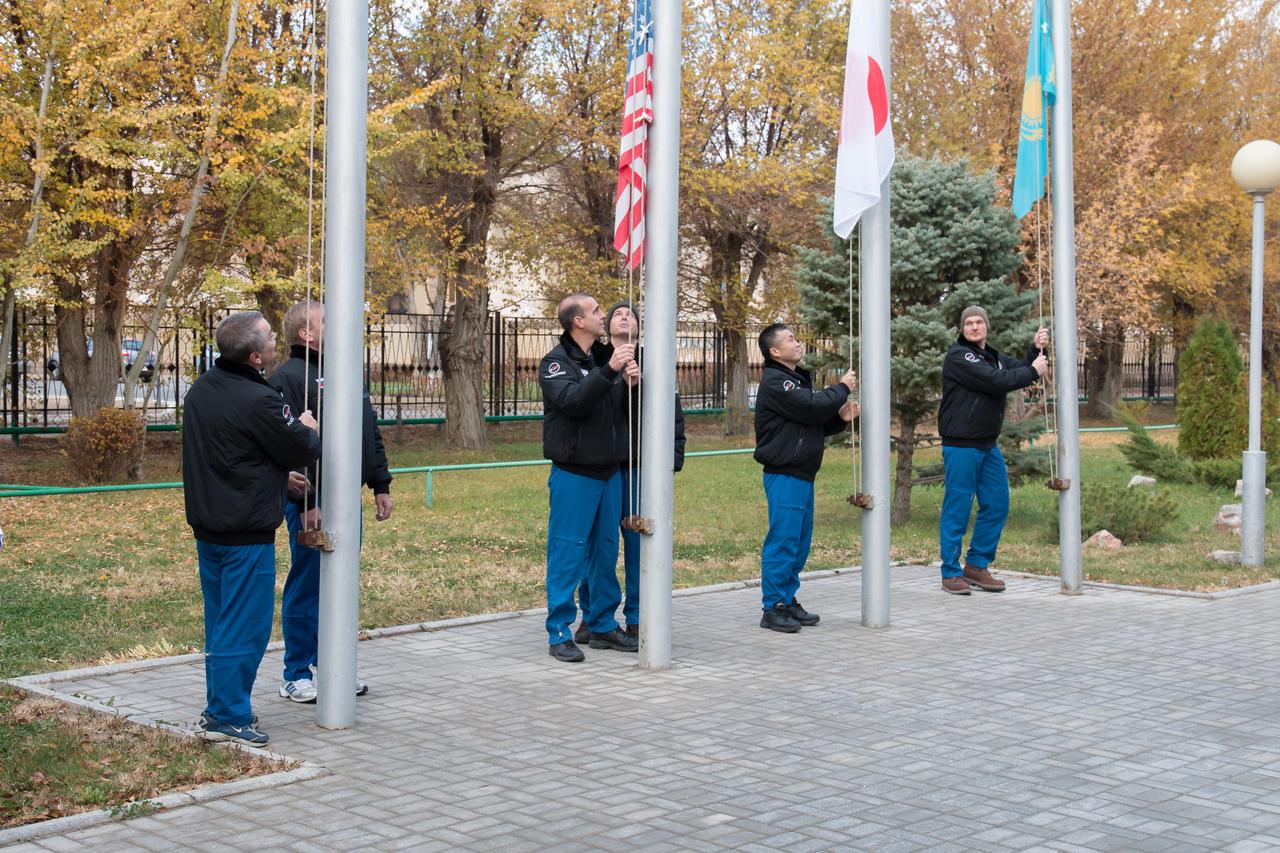Outside their Cosmonaut Hotel crew quarters in Baikonur, Kazakhstan, the Expedition 38/39 prime and backup crewmembers participated in the traditional flag-raising ceremony October 27 as they conduct final pre-launch preparations. From left to right, prime Soyuz Commander Mikhail Tyurin and backup Max Suraev raise the Russian flag, prime Flight Engineer Rick Mastracchio of NASA and backup Reid Wiseman of NASA raise the U.S. flag, prime Flight Engineer Koichi Wakata of the Japan Aerospace Exploration Agency raises the Japanese flag and backup Flight Engineer Alexander Gerst of the European Space Agency raises the flag of Kazakhstan. Wakata, Tyurin and Mastracchio will launch Nov. 7, Kazakh time, in the Soyuz TMA-11M spacecraft from Baikonur to begin a six-month mission on the International Space Station.  NASA/Victor Zelentsov 