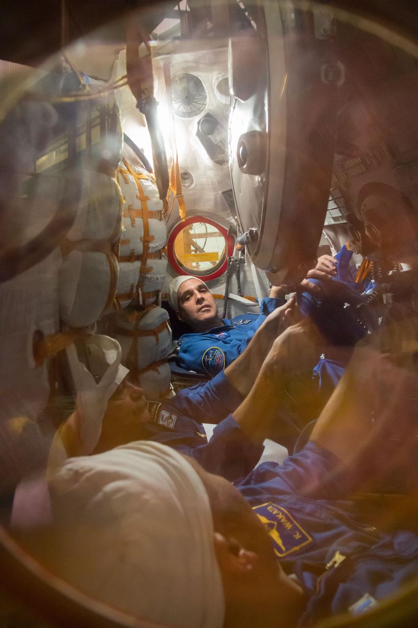 In the Integration Facility at the Baikonur Cosmodrome in Kazakhstan, Expedition 38/39 Flight Engineer Rick Mastracchio of NASA (top), Soyuz Commander Mikhail Tyurin (center) and Flight Engineer Koichi Wakata of the Japan Aerospace Exploration Agency (bottom) conduct a fit check dress rehearsal October 28 inside the Soyuz TMA-11M spacecraft. Mastracchio, Tyurin and Wakata will launch Nov. 7, Kazakh time, in the Soyuz from Baikonur to begin a six-month mission on the International Space Station.  NASA/Victor Zelentsov 