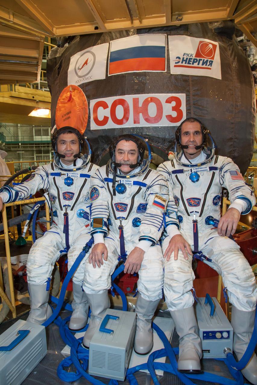 In the Integration Facility at the Baikonur Cosmodrome in Kazakhstan, Expedition 38/39 Flight Engineer Koichi Wakata of the Japan Aerospace Exploration Agency (left), Soyuz Commander Mikhail Tyurin (center) and Flight Engineer Rick Mastracchio of NASA (right) pose for pictures outside their Soyuz TMA-11M spacecraft October 28 following a fit check dress rehearsal. The trio will launch Nov. 7, Kazakh time, in the Soyuz spacecraft from Baikonur to begin a six-month mission on the International Space Station. NASA/Victor Zelentsov
