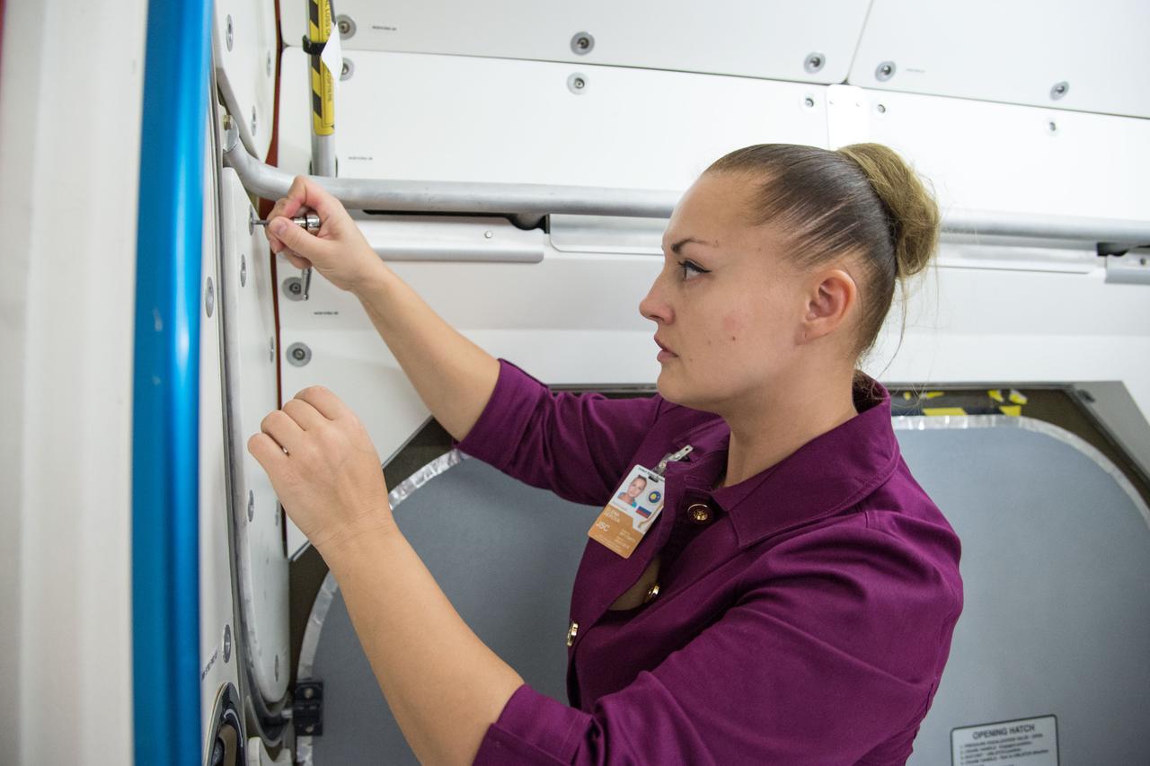 Date: 10-30-13 Location: Bldg 9NW, ISS Mockup Subject: Expedition 41/42 crew member and RSA cosmonaut Elena Serova during rack and hatch skills training in ISS mockups. Photographer: James Blair
