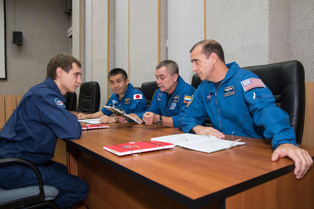 At their Cosmonaut Hotel crew quarters in Baikonur, Kazakhstan, Expedition 38/39 Flight Engineer Koichi Wakata of the Japan Aerospace Exploration Agency (left), Soyuz Commander Mikhail Tyurin (center) and Flight Engineer Rick Mastracchio of NASA (right) brush up on their flight plan with a training instructor Nov. 1 as they prepare for launch Nov. 7, Kazakh time, from the Baikonur Cosmodrome aboard the Soyuz TMA-11M spacecraft to begin a six-month mission on the International Space Station.  NASA/Victor Zelentsov 