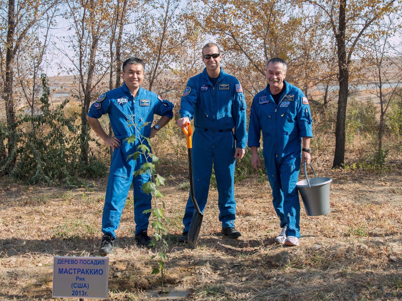 Behind their Cosmonaut Hotel crew quarters in Baikonur, Kazakhstan, Expedition 38/39 Flight Engineer Koichi Wakata of the Japan Aerospace Exploration Agency (left), Flight Engineer Rick Mastracchio of NASA (center) and Soyuz Commander Mikhail Tyurin (right) pose for pictures Nov. 1 after Mastracchio planted a tree in his name in a ceremonial pre-flight tradition. The trio is preparing for its launch Nov. 7, Kazakh time from the Baikonur Cosmodrome aboard the Soyuz TMA-11M spacecraft to begin a six-month mission on the International Space Station. NASA/Victor Zelentsov