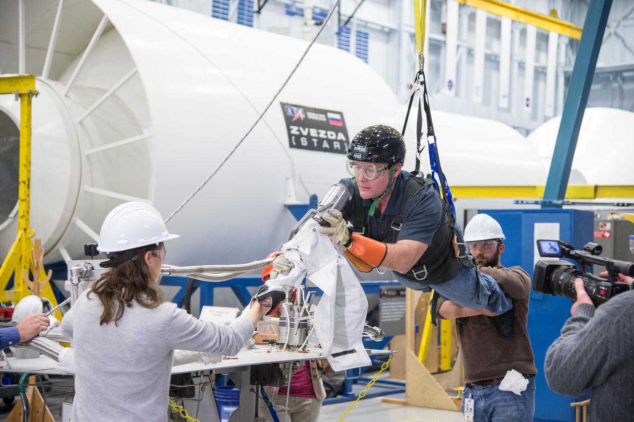 Date: 12/16/13 Location: Bldg 9NW, POGO Stand Subject: Doug Wheelock in POGO harness to evaluate EVA procedures and preparations for the ammonia coolant leak on ISS Photographer: James Blair/NASA