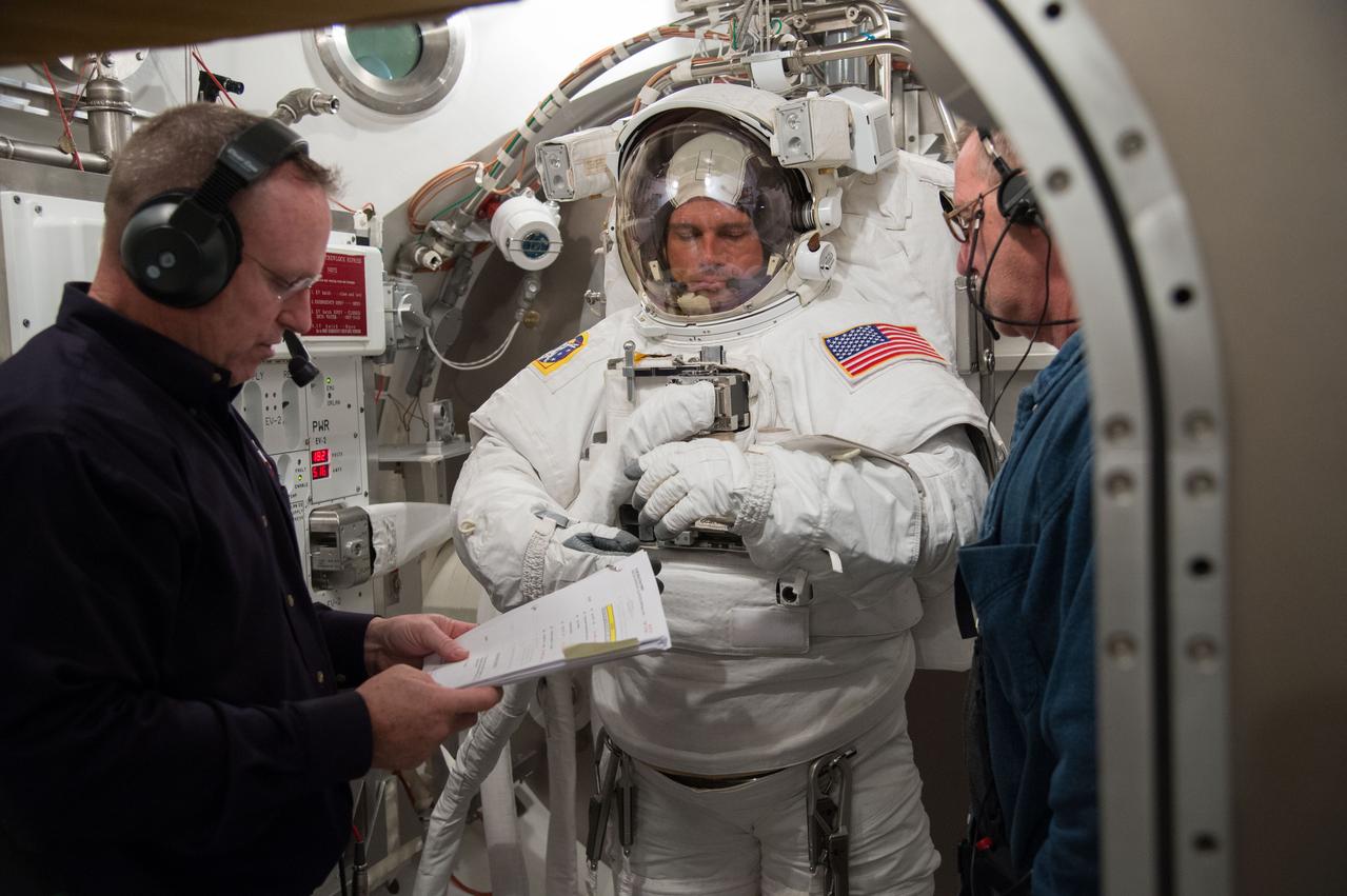 JSC2014-E-005645 (9 Jan. 2014) --- NASA astronaut Reid Wiseman, Expedition 40/41 flight engineer, participates in an Extravehicular Mobility Unit (EMU) spacesuit fit check in the Space Station Airlock Test Article (SSATA) of the Crew Systems Laboratory at NASA's Johnson Space Center. NASA astronaut Barry Wilmore (left), Expedition 41 flight engineer and Expedition 42 commander, assists Wiseman. Photo credit: NASA
