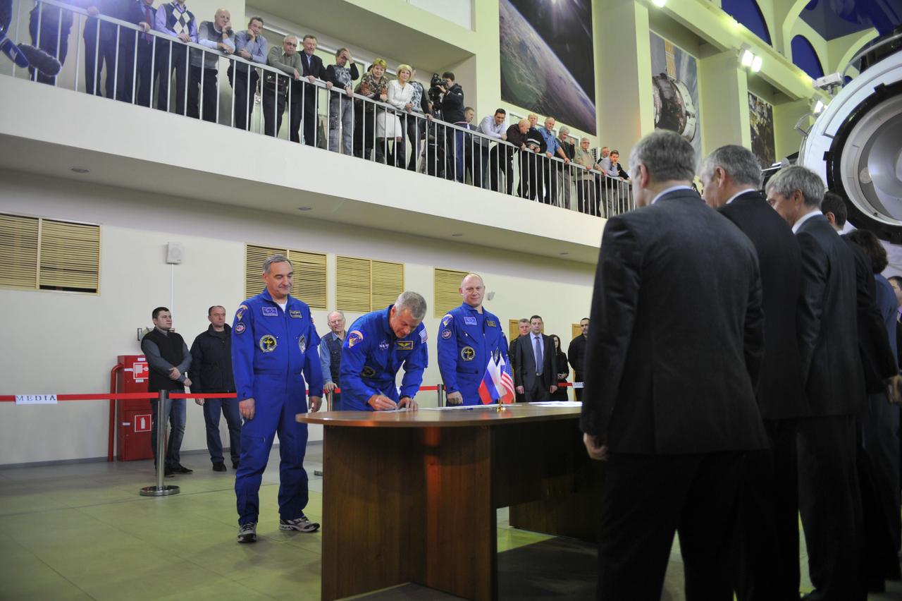 At the Gagarin Cosmonaut Training Center in Star City, Russia, Expedition 39/40 Flight Engineer Steve Swanson of NASA (center) signs in for the start of qualification exams March 4 as his crewmates, Soyuz Commander Alexander Skvortsov of Roscosmos (left) and Flight Engineer Oleg Artemyev of Roscosmos (right) look on. The trio is preparing for launch to the International Space Station from the Baikonur Cosmodrome in Kazakhstan on March 26, Kazakh time in their Soyuz TMA-12M spacecraft for a six-month mission.  NASA/Stephanie Stoll 