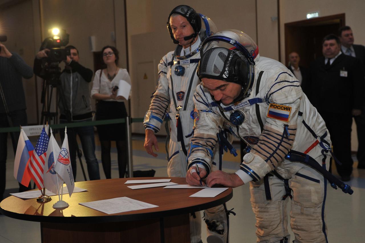 JSC2014-E-024812 (5 March 2014) --- At the Gagarin Cosmonaut Training Center in Star City, Russia, Expedition 39/40 Soyuz Commander Alexander Skvortsov of Roscosmos (right) signs in for final qualification exams March 5 as his crewmate, NASA Flight Engineer Steve Swanson looks on. Skvortsov, Swanson and Flight Engineer Oleg Artemyev of Roscosmos are preparing for their launch to the International Space Station from the Baikonur Cosmodrome in Kazakhstan March 26, Kazakh time, in their Soyuz TMA-12M spacecraft for a six-month mission. Photo credit: NASA