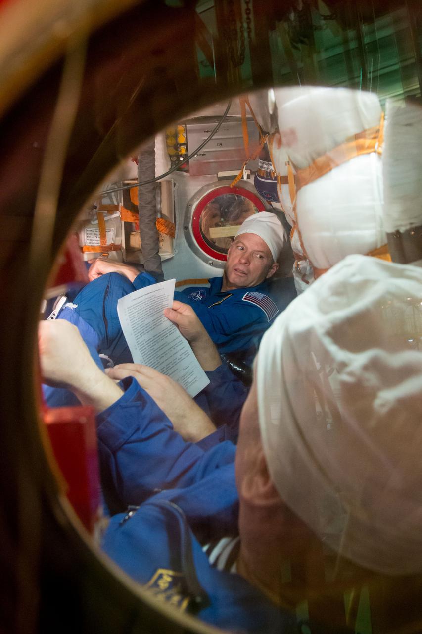 2014-03-14-10-48-03-3[1] In the Integration Facility at the Baikonur Cosmodrome in Kazakhstan, Expedition 39/40 Flight Engineer Steve Swanson of NASA reviews procedures in the Soyuz TMA-12M spacecraft during a “fit check” dress rehearsal exercise March 14 that is part of the crew’s final training. Swanson, Soyuz Commander Alexander Skvortsov of the Russian Federal Space Agency (Roscosmos; hidden from view) and Flight Engineer Oleg Artemyev of Roscosmos (foreground) are scheduled to launch to the International Space Station March 26 (Kazakh time) for the start of a six-month mission.  NASA/Victor Zelentsov  