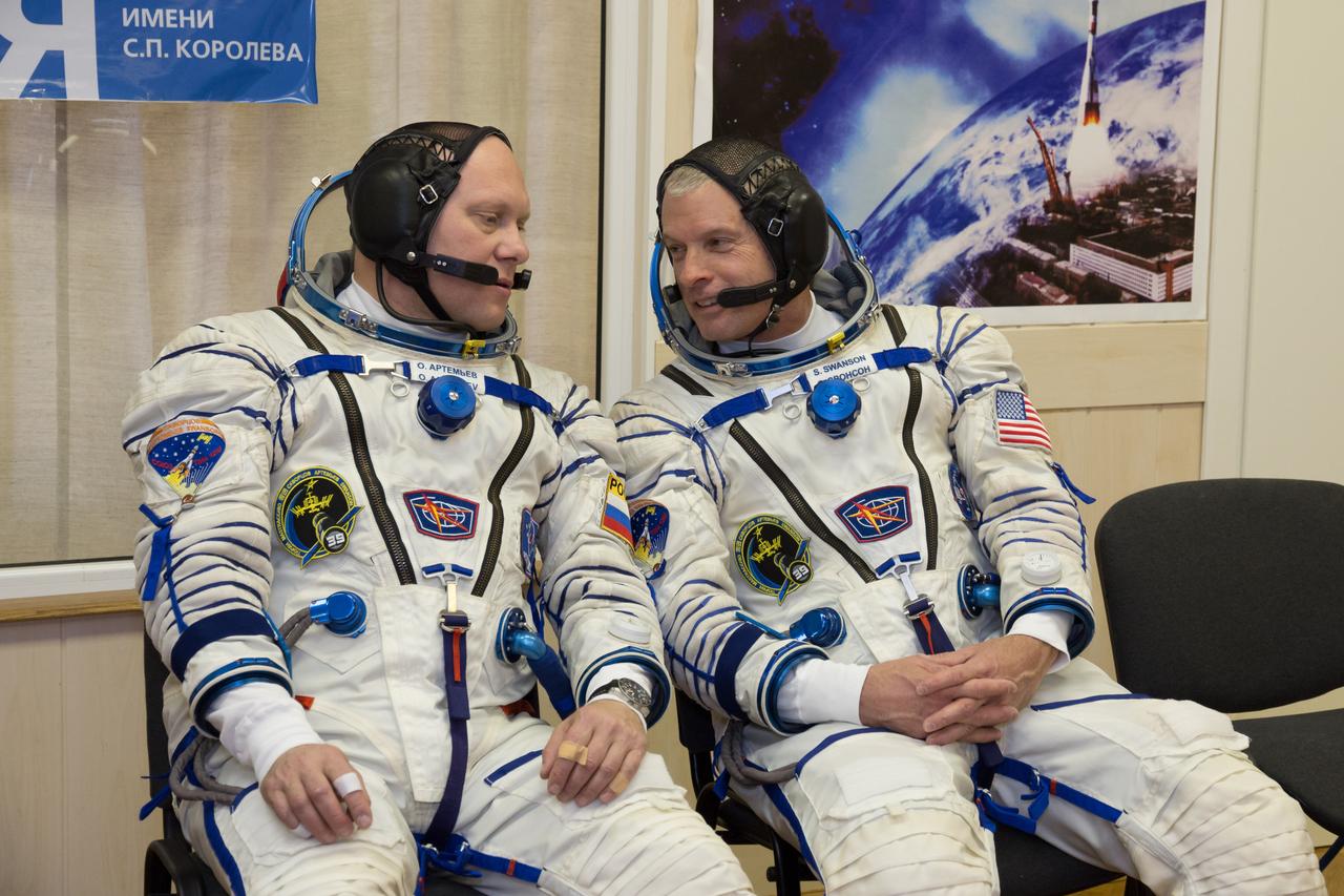 2014-03-14-12-43-15[1] In the Integration Facility at the Baikonur Cosmodrome in Kazakhstan, Expedition 39/40 Flight Engineer Steve Swanson of NASA (right) shares a word with crewmate and Flight Engineer Oleg Artemyev of the Russian Federal Space Agency (Roscosmos) during a “fit check” dress rehearsal March 14 that is part of the crew’s final training. Swanson, Artemyev and Soyuz Commander Alexander Skvortsov of Roscosmos are scheduled to launch to the International Space Station March 26 (Kazakh time) for the start of a six-month mission.  NASA/Victor Zelentsov 