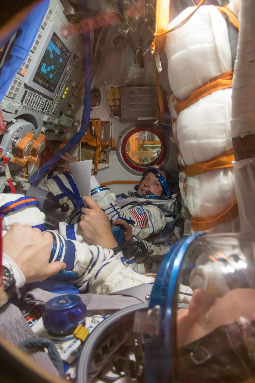 2014-03-14-14-15-17[1] In the Integration Facility at the Baikonur Cosmodrome in Kazakhstan, Expedition 39/40 Flight Engineer Steve Swanson of NASA poses for a picture in the Soyuz TMA-12M spacecraft during a “fit check” dress rehearsal exercise March 14 that is part of the crew’s final training. Swanson, Soyuz Commander Alexander Skvortsov of the Russian Federal Space Agency (Roscosmos) and Flight Engineer Oleg Artemyev of Roscosmos are scheduled to launch to the International Space Station March 26 (Kazakh time) for the start of a six-month mission.  NASA/Victor Zelentsov 