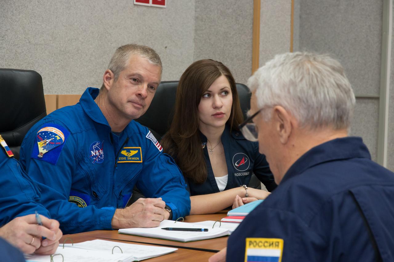 19-11-04-07:  Assisted by an interpreter, Expedition 39/40 Flight Engineer Steve Swanson of NASA reviews rendezvous procedures with a training instructor at his Cosmonaut Hotel crew quarters in Baikonur, Kazakhstan March 19. Swanson, Soyuz Commander Alexander Skvortsov of the Russian Federal Space Agency (Roscosmos) and Flight Engineer Oleg Artemyev of Roscosmos are scheduled to launch to the International Space Station March 26, Kazakh time, in the Soyuz TMA-12M spacecraft for a six-month mission.  NASA/Victor Zelentsov 