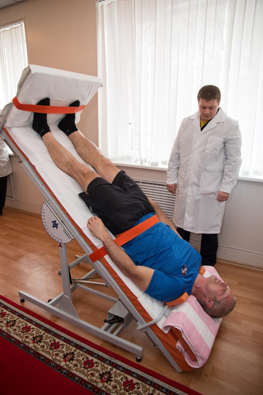 19-12-34-54: At his Cosmonaut Hotel crew quarters in Baikonur, Kazakhstan, Expedition 39/40 Flight Engineer Steve Swanson of NASA takes a turn on a tilt table March 19 as part of his conditioning in preparation for launch to the International Space Station with his crewmates, Alexander Skvortsov and Oleg Artemyev of the Russian Federal Space Agency (Roscosmos) on March 26, Kazakh time, in the Soyuz TMA-12M spacecraft for a six-month mission. NASA/Victor Zelentsov