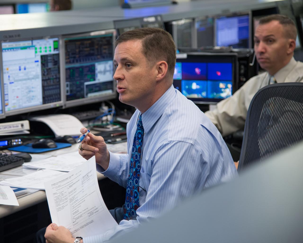 Expedition 39 flight controllers on console during SpaceX cargo rendezvous and grappling. Flight Director: Matt Abbott. Capcoms: Jack Fischer and Randy Bresnik. Photo Date: April 20, 2014. Location: Building 30 - FCR-1. Photographer: Robert Markowitz