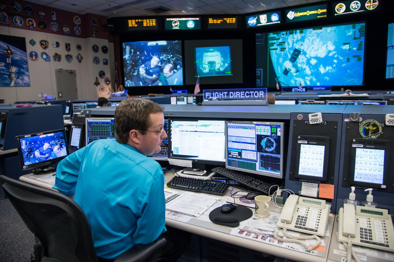 Expedition 39 flight controllers on console during SpaceX cargo rendezvous and grappling. Flight Director: Matt Abbott. Capcoms: Jack Fischer and Randy Bresnik. Photo Date: April 20, 2014. Location: Building 30 - FCR-1. Photographer: Robert Markowitz