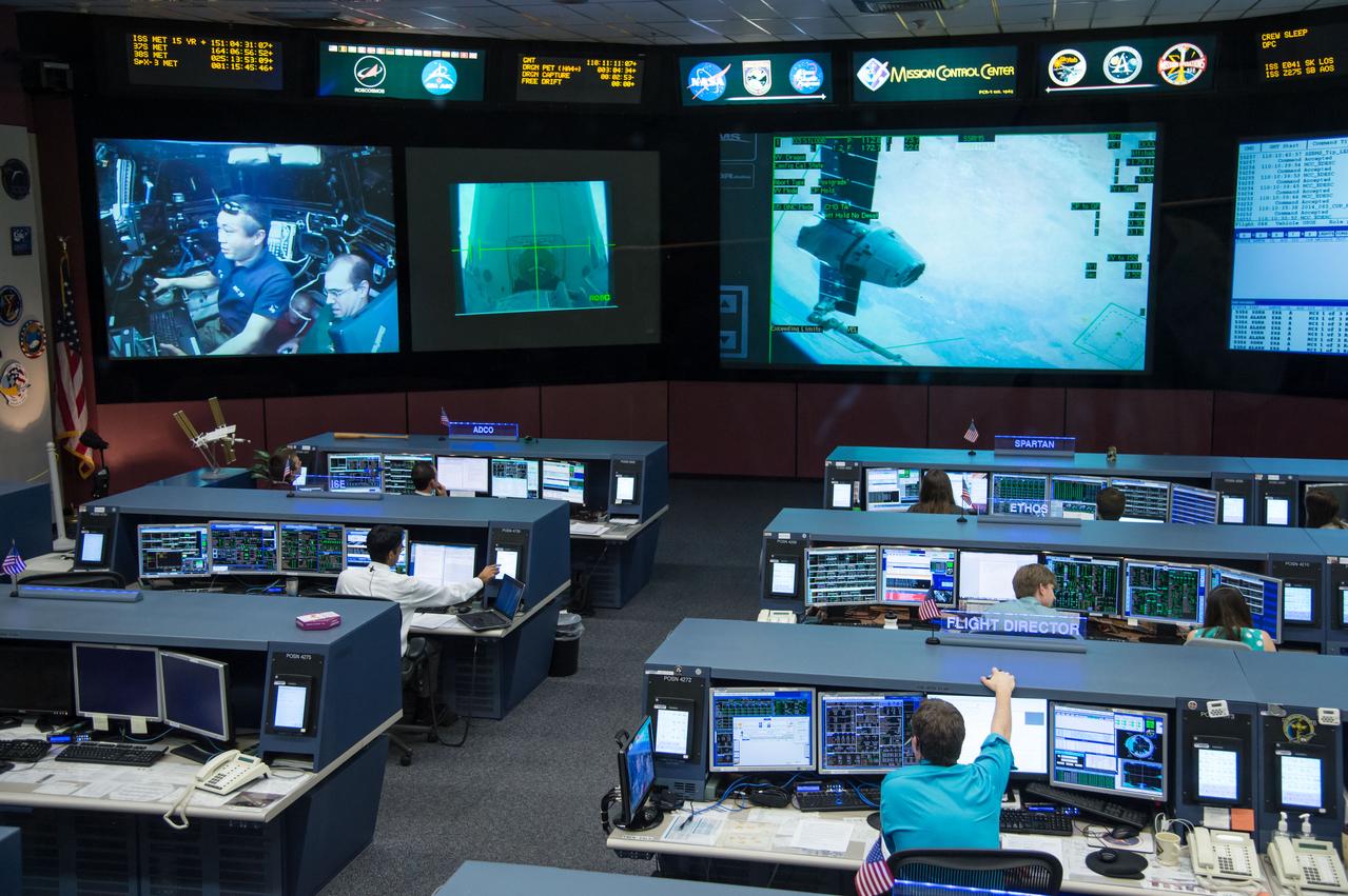 Expedition 39 flight controllers on console during SpaceX cargo rendezvous and grappling. Flight Director: Matt Abbott. Capcoms: Jack Fischer and Randy Bresnik. Photo Date: April 20, 2014. Location: Building 30 - FCR-1. Photographer: Robert Markowitz