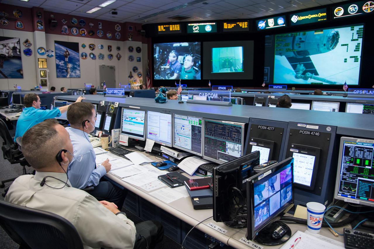 Expedition 39 flight controllers on console during SpaceX cargo rendezvous and grappling. Flight Director: Matt Abbott. Capcoms: Jack Fischer and Randy Bresnik. Photo Date: April 20, 2014. Location: Building 30 - FCR-1. Photographer: Robert Markowitz