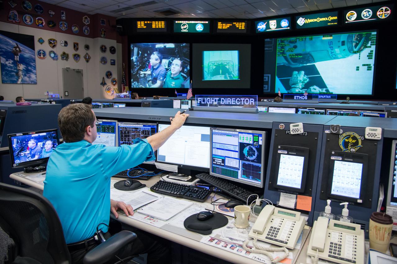 Expedition 39 flight controllers on console during SpaceX cargo rendezvous and grappling. Flight Director: Matt Abbott. Capcoms: Jack Fischer and Randy Bresnik. Photo Date: April 20, 2014. Location: Building 30 - FCR-1. Photographer: Robert Markowitz
