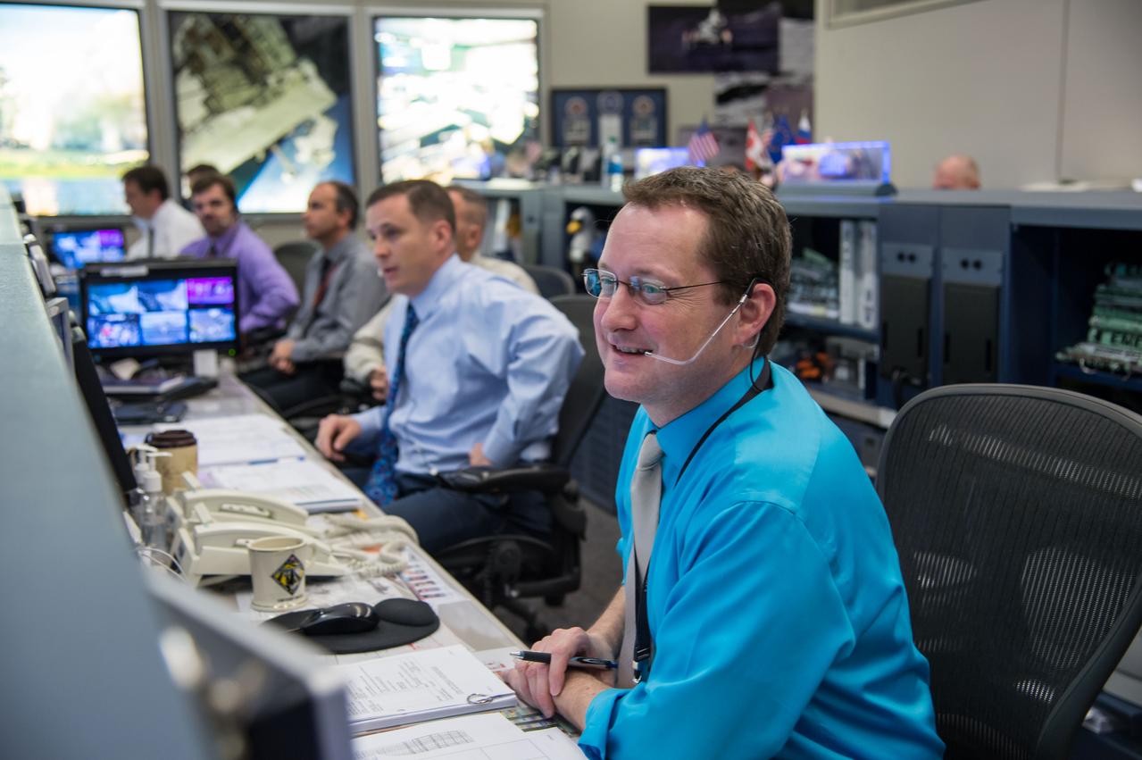 Expedition 39 flight controllers on console during SpaceX cargo rendezvous and grappling. Flight Director: Matt Abbott. Capcoms: Jack Fischer and Randy Bresnik. Photo Date: April 20, 2014. Location: Building 30 - FCR-1. Photographer: Robert Markowitz