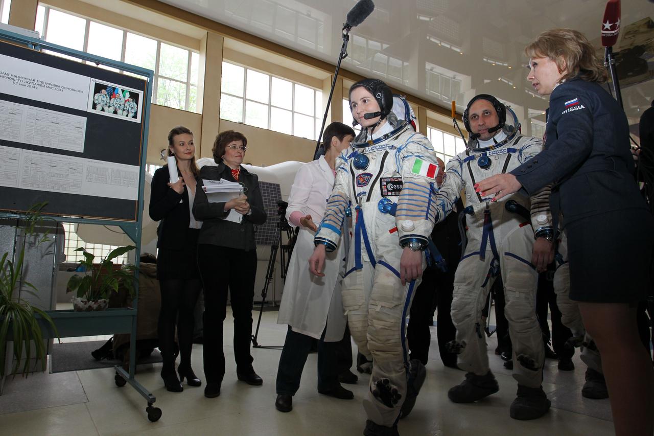 0165:  At the Gagarin Cosmonaut Training Center in Star City, Russia, Expedition 40/41 backup crewmember Samantha Cristoforetti of the European Space Agency (foreground) walks to a Soyuz simulator May 6 along with Soyuz commander Anton Shkaplerov of the Russian Federal Space Agency (Roscosmos, second from the right) to begin two days of final qualification exams. Cristoforetti, Shkaplerov and Terry Virts of NASA are serving as backups to the prime crewmembers --- Reid Wiseman of NASA, Max Suraev of Roscosmos and Alexander Gerst of the European Space Agency, who are preparing for launch on May 29, Kazakh time, on the Soyuz TMA-13M spacecraft from the Baikonur Cosmodrome in Kazakhstan for a 5 ½ month mission on the  International Space Station.  NASA/Stephanie Stoll 