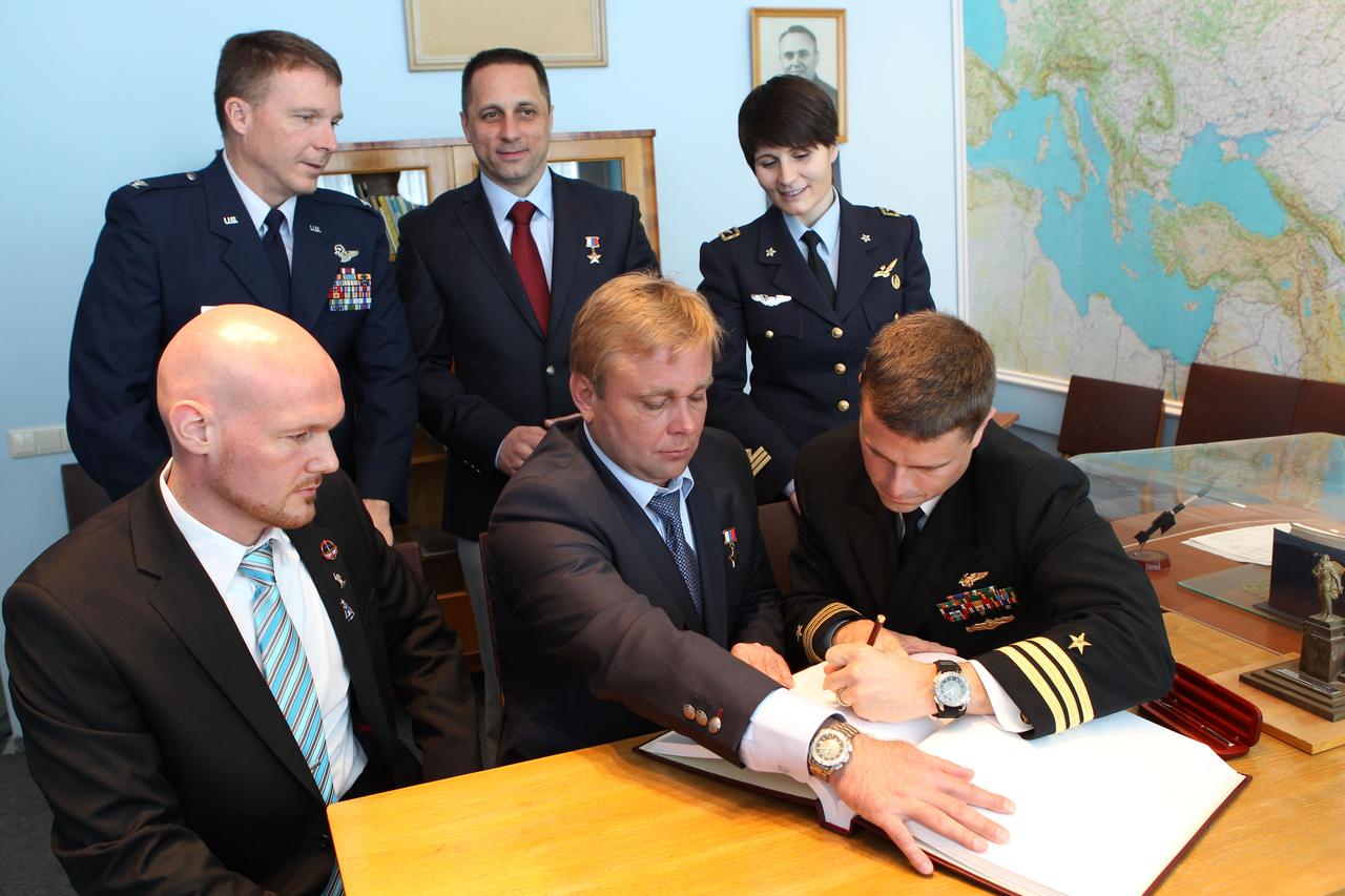 0850:  At the Gagarin Cosmonaut Training Center in Star City, Russia, Expedition 40/41 Flight Engineer Reid Wiseman of NASA (front row, right) signs a ceremonial book during a tour of the Gagarin Museum May 8 as his crewmates and their backups look on. Also pictured are prime crewmember Alexander Gerst of the European Space Agency (front row, left) and Soyuz Commander Max Suraev of the Russian Federal Space Agency (Roscosmos, front row, center) and backup crewmembers Terry Virts of NASA (back row, left), Anton Shkaplerov of Roscosmos (back row, center) and Samantha Cristoforetti of the European Space Agency (back row, right). Wiseman, Gerst, and Suraev are preparing for launch May 29, Kazakh time, from the Baikonur Cosmodrome in Kazakhstan on the Soyuz TMA-13M spacecraft for a 5 ½ month mission on the International Space Station.  NASA/Stephanie Stoll 