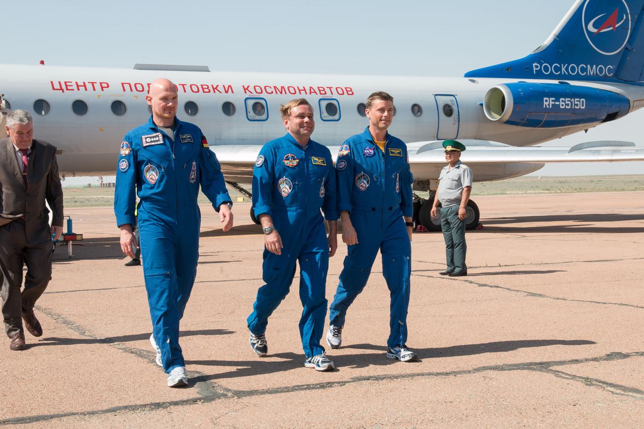 15-16-18-53:  Striding off the aircraft that carried them to the Baikonur Cosmodrome in Kazakhstan for final pre-launch training, Expedition 40/41 Flight Engineer Alexander Gerst of the European Space Agency (left), Soyuz Commander Max Suraev of the Russian Federal Space Agency (Roscosmos, center) and NASA Flight Engineer Reid Wiseman (right) prepare to greet Russian space officials in Baikonur May 15 who gathered for their arrival. Behind them is former cosmonaut Valery Korzun, now the Deputy Head of the Gagarin Cosmonaut Training Center in Star City, Russia. The trio will launch May 29, Kazakh time, in their Soyuz TMA-13M spacecraft from Baikonur for a 5 ½ month mission on the International Space Station.  NASA/Victor Zelentsov 