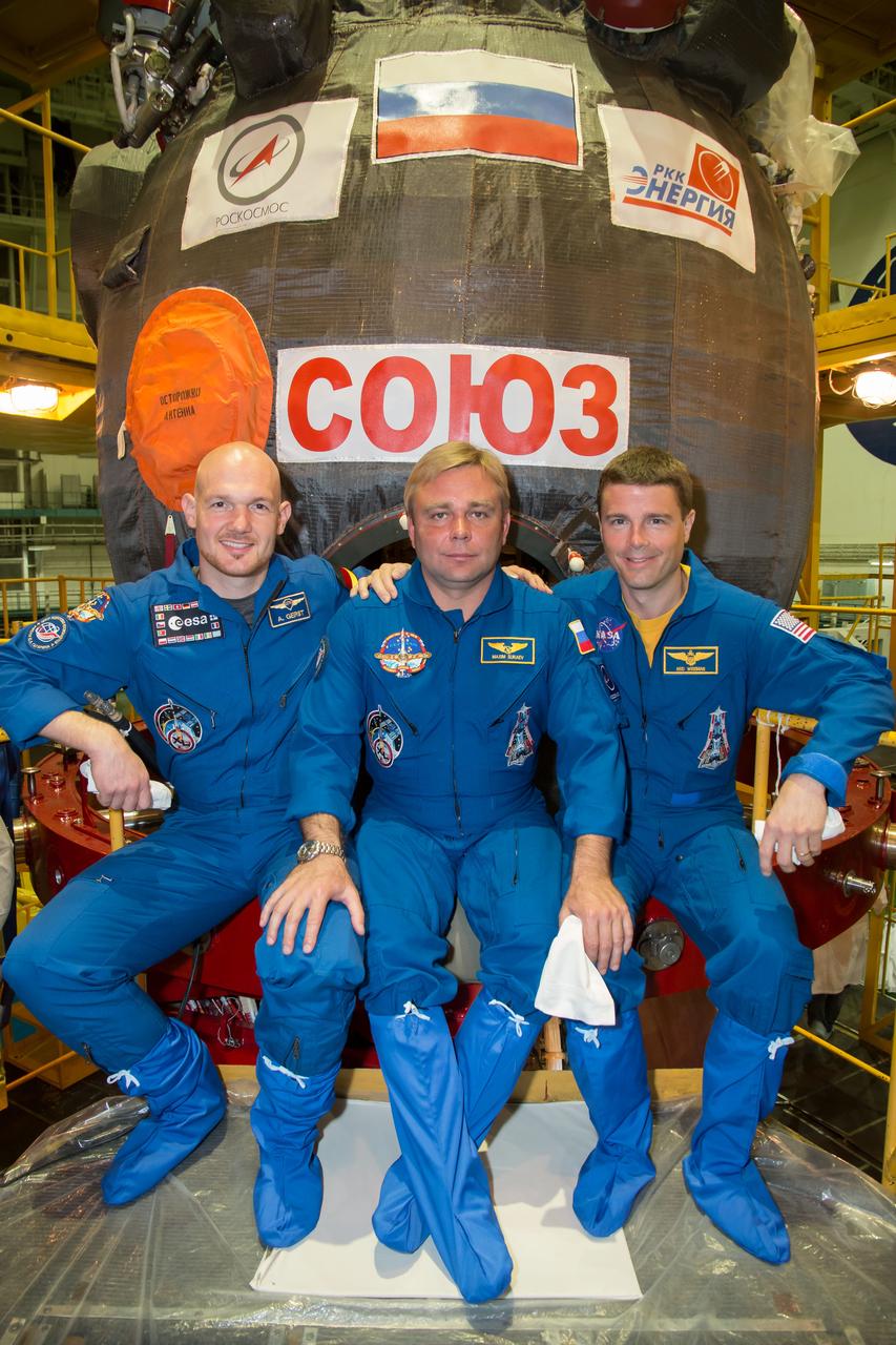10-13-43-3:  At the Baikonur Cosmodrome in Kazakhstan, Expedition 40/41 Flight Engineer Alexander Gerst of the European Space Agency (left), Soyuz Commander Max Suraev of the Russian Federal Space Agency (Roscosmos, center) and NASA Flight Engineer Reid Wiseman (right) pose for pictures in front of their Soyuz TMA-13M spacecraft during a dress rehearsal “fit check” May 16. The trio will launch from Baikonur on May 29, Kazakh time, for a 5 ½ month mission on the International Space Station.  NASA/Victor Zelentsov 