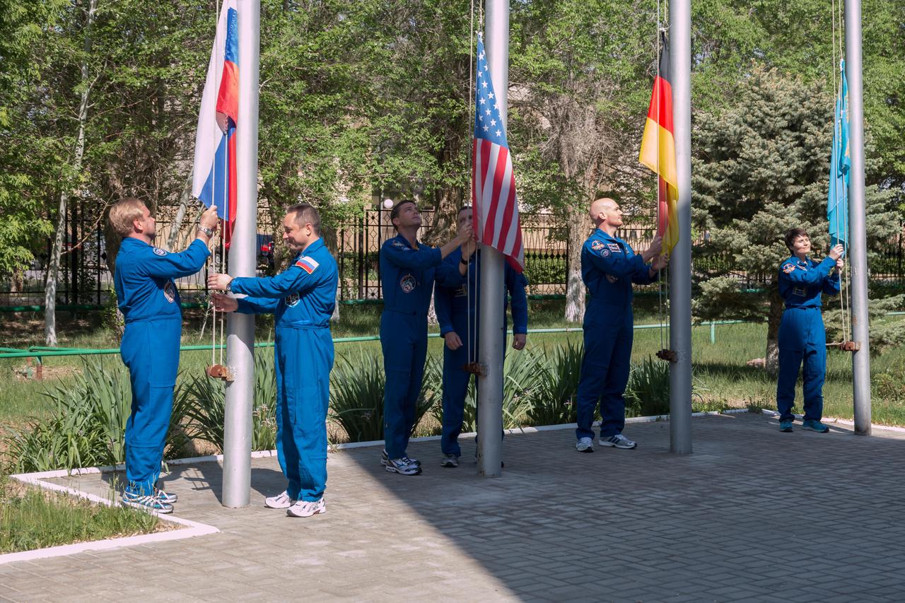 11-04-30:  At the Cosmonaut Hotel crew quarters in Baikonur, Kazakhstan, the Expedition 40/41 prime and backup crewmembers raise the flags of Russia, the United States, Germany and Kazakhstan during traditional ceremonies May 17. From left to right are prime Soyuz Commander Max Suraev of the Russian Federal Space Agency (Roscosmos) and his backup, Anton Shkaplerov, prime Flight Engineer Reid Wiseman of NASA and his backup, NASA’s Terry Virts, prime Flight Engineer Alexander Gerst of Germany and the European Space Agency and backup Samantha Cristoforetti of the European Space Agency. Wiseman, Suraev and Gerst will launch from Baikonur on May 29, Kazakh time, on the Soyuz TMA-13M spacecraft for a 5 ½ month mission on the International Space Station.  NASA/Victor Zelentsov 