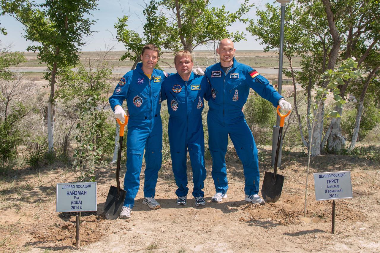 14-14-48-2:  At the Cosmonaut Hotel crew quarters in Baikonur, Kazakhstan, Expedition 40/41 Flight Engineer Reid Wiseman of NASA (left), Soyuz Commander Max Suraev of the Russian Federal Space Agency (Roscosmos, center) and Flight Engineer Alexander Gerst of the European Space Agency (right) pose for pictures May 21 after planting trees bearing the names of Wiseman and Gerst in traditional pre-launch ceremonies. Wiseman, Suraev and Gerst will launch on May 29, Kazakh time, on the Soyuz TMA-13M spacecraft from the Baikonur Cosmodrome for a 5 ½ month mission on the International Space Station.  NASA/Victor Zelentsov 