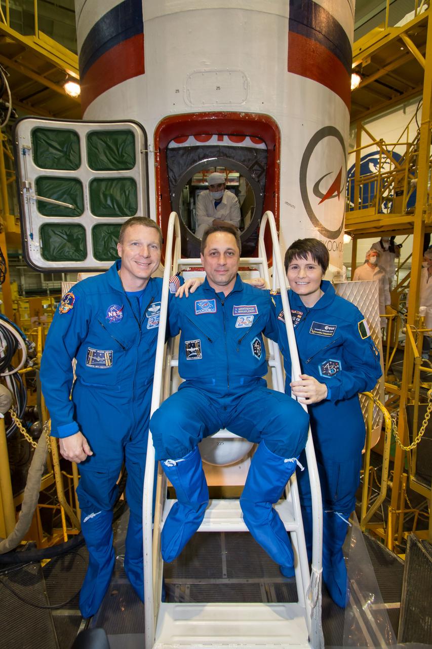 14-11-3:  At the Baikonur Cosmodrome in Kazakhstan, Expedition 40/41 backup crewmembers Terry Virts of NASA (left), Anton Shkaplerov of the Russian Federal Space Agency (Roscosmos, center) and Samantha Cristoforetti of the European Space Agency (right) pose for pictures in front of the Soyuz TMA-13M spacecraft May 24 during the final fit check training dress rehearsal. The trio are backups to the prime crew --- Reid Wiseman of NASA, Max Suraev of Roscosmos and Alexander Gerst of NASA, who will launch May 29, Kazakh time, on the Soyuz TMA-13M spacecraft for a 5 ½ month mission on the International Space Station.  NASA/Victor Zelentsov 