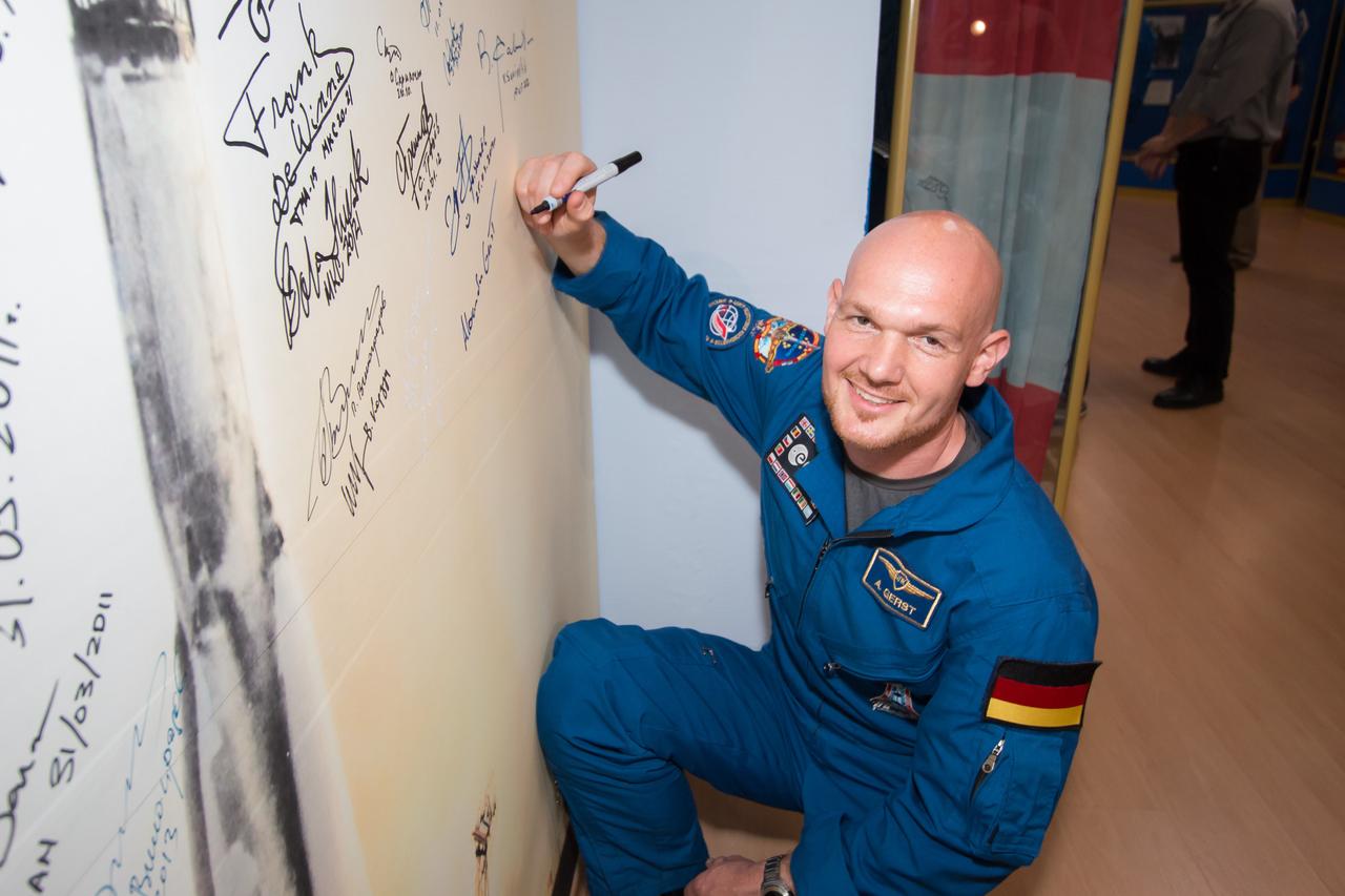 13-49-32-4:  Inside the Korolev Museum at the Baikonur Cosmodrome in Kazakhstan, Expedition 40/41 Flight Engineer Alexander Gerst of the European Space Agency signs his name to a wall mural bearing the picture of a Soyuz rocket launch May 24 during traditional pre-launch ceremonies. Gerst, Soyuz Commander Max Suraev of the Russian Federal Space Agency (Roscosmos) and Flight Engineer Reid Wiseman of NASA will launch May 29, Kazakh time, on the Soyuz TMA-13M spacecraft for a 5 ½ month mission on the International Space Station.  NASA/Victor Zelentsov 