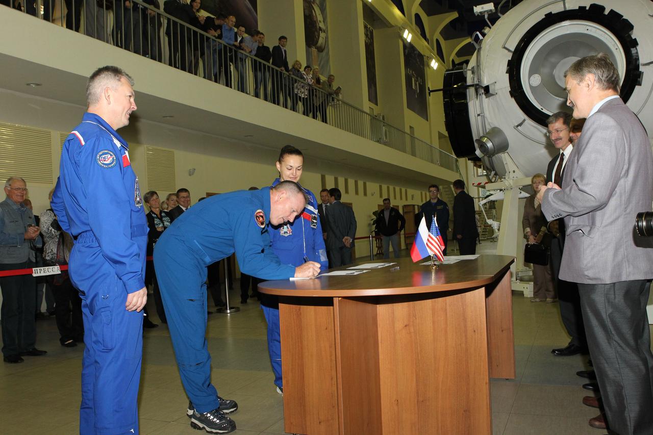 1881:  At the Gagarin Cosmonaut Training Center in Star City, Russia, Expedition 41/42 Flight Engineer Barry Wilmore of NASA (center) signs in at the start of final qualification exams September 3 as his crewmates, Alexander Samokutyaev of the Russian Federal Space Agency (Roscosmos, left) and Elena Serova of Roscosmos (right) look on. They will launch September 26 from the Baikonur Cosmodrome in Kazakhstan, Kazakh time, in the Soyuz TMA-14M spacecraft for a 5 ½ month mission on the International Space Station. Serova will become only the fourth Russian woman to fly in space and the first Russian woman to conduct a long duration mission on the station.  NASA/Stephanie Stoll 
