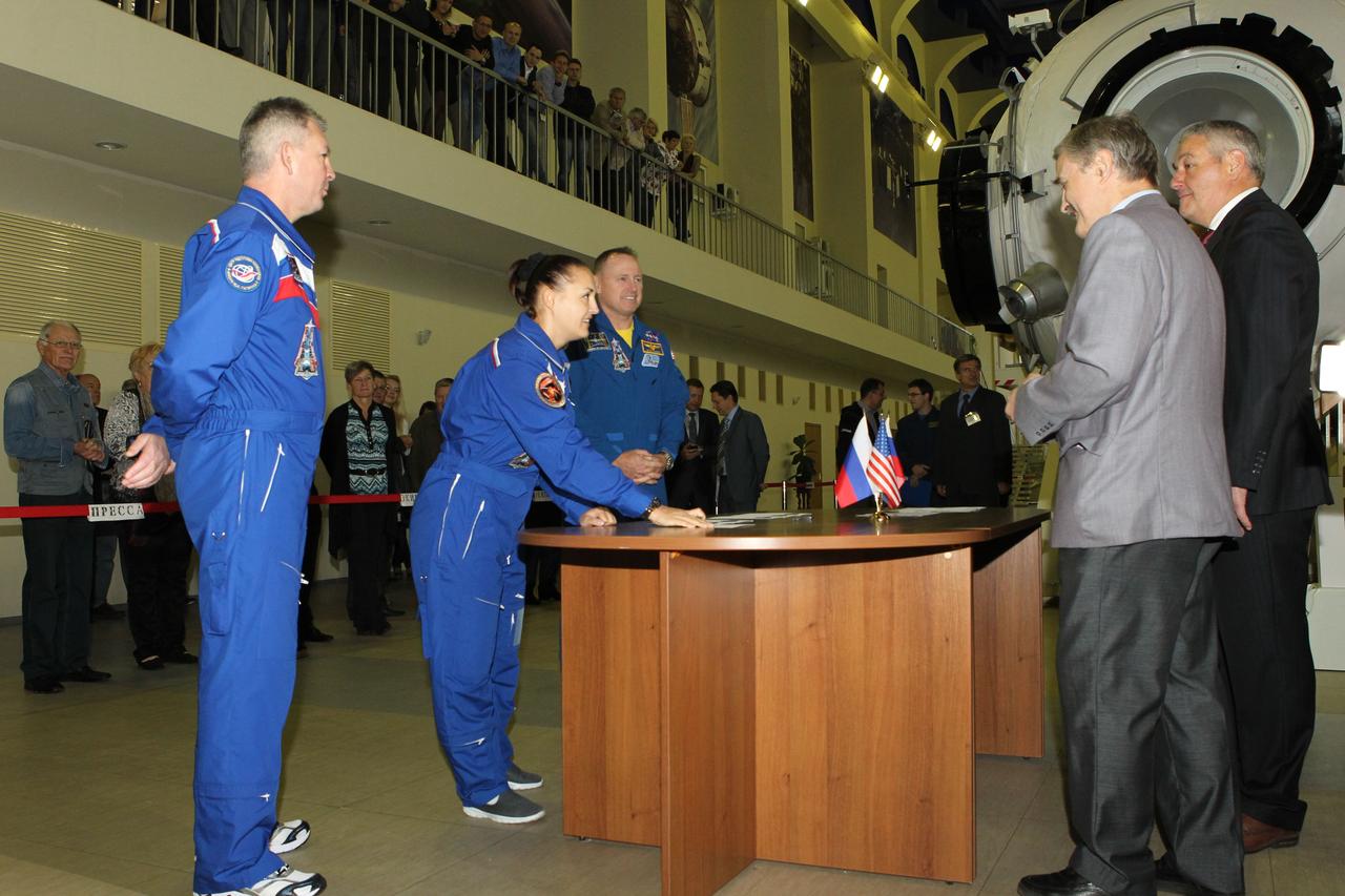 1898:  At the Gagarin Cosmonaut Training Center in Star City, Russia, Expedition 41/42 Flight Engineer Elena Serova of the Russian Federal Space Agency (Roscosmos, center) signs in at the start of final qualification exams September 3 as her crewmates, Alexander Samokutyaev of Roscosmos (left) and Barry Wilmore of NASA (right) look on. They will launch September 26 from the Baikonur Cosmodrome in Kazakhstan, Kazakh time, in the Soyuz TMA-14M spacecraft for a 5 ½ month mission on the International Space Station. Serova will become only the fourth Russian woman to fly in space and the first Russian woman to conduct a long duration mission on the station.  NASA/Stephanie Stoll 