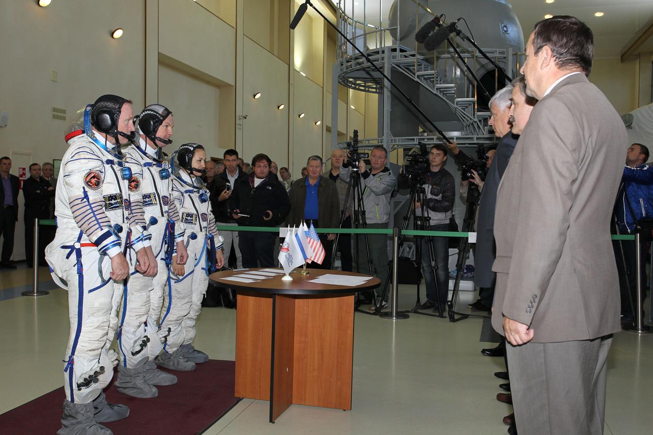 2037:  At the Gagarin Cosmonaut Training Center in Star City, Russia, Expedition 41/42 prime crewmembers Barry Wilmore of NASA (left), Alexander Samokutyaev of the Russian Federal Space Agency (Roscosmos, center) and Elena Serova of Roscosmos (right) listen to instructions from officials September 4 at the start of the second day of final qualification exams. The trio will launch from the Baikonur Cosmodrome in Kazakhstan, Sept. 26, Kazakh time, in their Soyuz TMA-14M spacecraft for a 5 ½ month mission on the International Space Station. Serova will become the fourth Russian woman to fly in space and the first Russian woman to conduct a long duration mission on the station.  NASA/Stephanie Stoll 