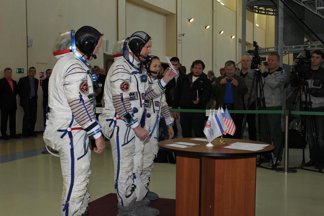 2044:  At the Gagarin Cosmonaut Training Center in Star City, Russia, Expedition 41/42 Soyuz Commander Alexander Samokutyaev of the Russian Federal Space Agency (Roscosmos, center) holds up a sign-in card September 4 at the start of the second day of final qualification exams. Looking on are crewmates Barry Wilmore of NASA (left) and Elena Serova of Roscosmos (right). The trio will launch from the Baikonur Cosmodrome in Kazakhstan, Sept. 26, Kazakh time, in their Soyuz TMA-14M spacecraft for a 5 ½ month mission on the International Space Station. Serova will become the fourth Russian woman to fly in space and the first Russian woman to conduct a long duration mission on the station.  NASA/Stephanie Stoll 