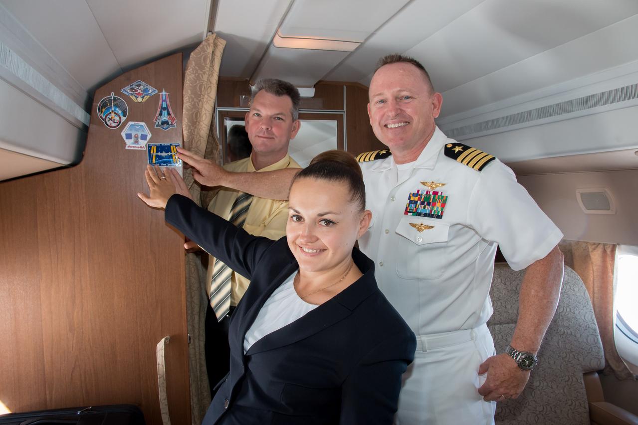 12-14-35-03:  Aboard a Gagarin Cosmonaut Training Center aircraft, Expedition 41/42 Soyuz Commander Alexander Samokutyaev of the Russian Federal Space Agency (Roscosmos, left), Flight Engineer Elena Serova of Roscosmos (center) and NASA Flight Engineer Barry Wilmore (right) affix their Expedition crew decal to the wall of the cabin Sept. 12 en route to their launch site at the Baikonur Cosmodrome in Kazakhstan for final pre-launch training. The trio will launch from Baikonur on Sept. 26, Kazakh time, in their Soyuz TMA-14M spacecraft for a 5 ½ month mission on the International Space Station. Serova will become the fourth Russian woman to fly in space.  NASA/Victor Zelentsov 