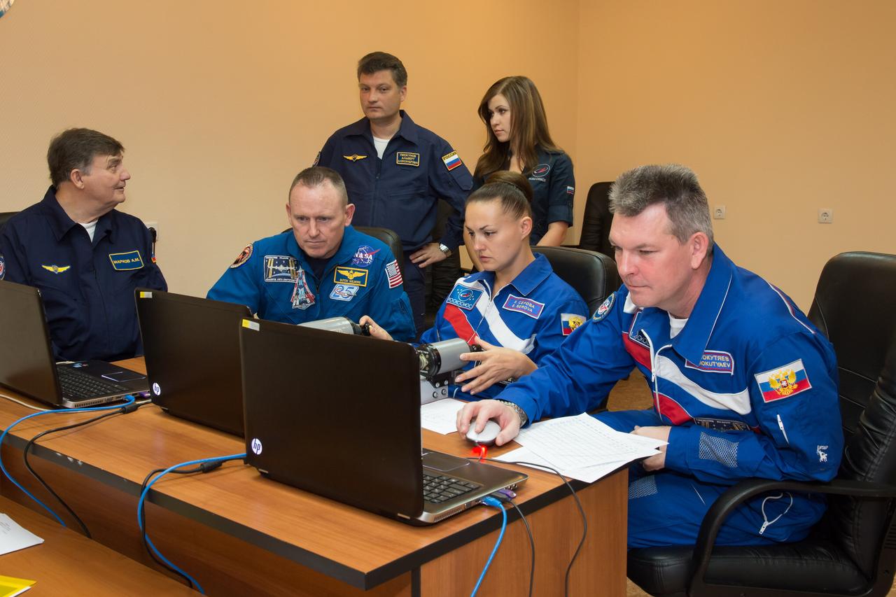 17-11-13-47-2: (17 Sept. 2014) --- At the Cosmonaut Hotel crew quarters in Baikonur, Kazakhstan, Expedition 41/42 Soyuz Commander Alexander Samokutyaev of the Russian Federal Space Agency (Roscosmos), right, brushes up on docking skills on a laptop computer simulator Sept. 17 as pre-launch preparations continue for the crew. Looking on are NASA Flight Engineer Barry Wilmore (left) and Flight Engineer Elena Serova of Roscosmos. The trio will launch from the Baikonur Cosmodrome Sept. 26, Kazakh time, in the Soyuz TMA-14M spacecraft for a 5 ½ month mission on the International Space Station. Serova will become the fourth Russian woman to fly in space and the first Russian woman to live and work on the station. Photo credit: NASA/Victor Zelentsov