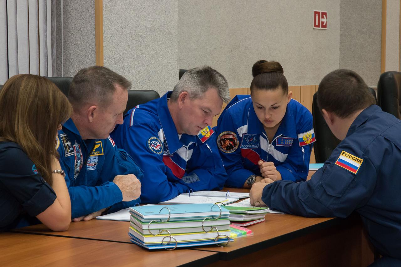 17-11-26-58-2:  (17 Sept. 2014) --- At the Cosmonaut Hotel crew quarters in Baikonur, Kazakhstan, Expedition 41/42 Flight Engineer Barry Wilmore of NASA (left), Soyuz Commander Alexander Samokutyaev of the Russian Federal Space Agency (Roscosmos) center, and Flight Engineer Elena Serova of Roscosmos listen intently Sept. 17 as instructors review flight procedures for their upcoming launch. The trio will launch from the Baikonur Cosmodrome Sept. 26, Kazakh time, in the Soyuz TMA-14M spacecraft for a 5 ½ month mission on the International Space Station. Serova will become the fourth Russian woman to fly in space and the first Russian woman to live and work on the station.   Photo credit:  NASA/Victor Zelentsov 