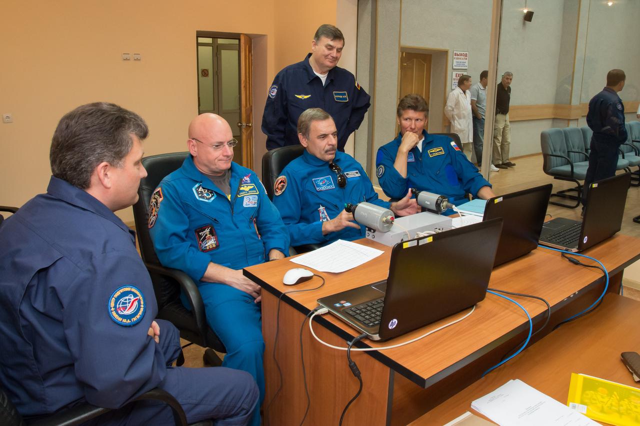 17-11-28-20-2: (17 Sept. 2014) --- At the Cosmonaut Hotel crew quarters in Baikonur, Kazakhstan, Expedition 41/42 backup crewmembers Scott Kelly of NASA (left), Mikhail Kornienko of the Russian Federal Space Agency (Roscosmos), center, and Gennady Padalka of Roscosmos brush up on rendezvous and docking skills Sept. 17 on a laptop computer simulator. The three are backups to Flight Engineer Barry Wilmore of NASA, Soyuz Commander Alexander Samokutyaev of Roscosmos and Flight Engineer Elena Serova of Roscosmos who are scheduled to launch from the Baikonur Cosmodrome Sept. 26, Kazakh time, in the Soyuz TMA-14M spacecraft for a 5 ½ month mission on the International Space Station. Serova will become the fourth Russian woman to fly in space and the first Russian woman to live and work on the station. Kelly and Kornienko will launch in March 2015 to spend a full year on the station. Photo credit: NASA/Victor Zelentsov