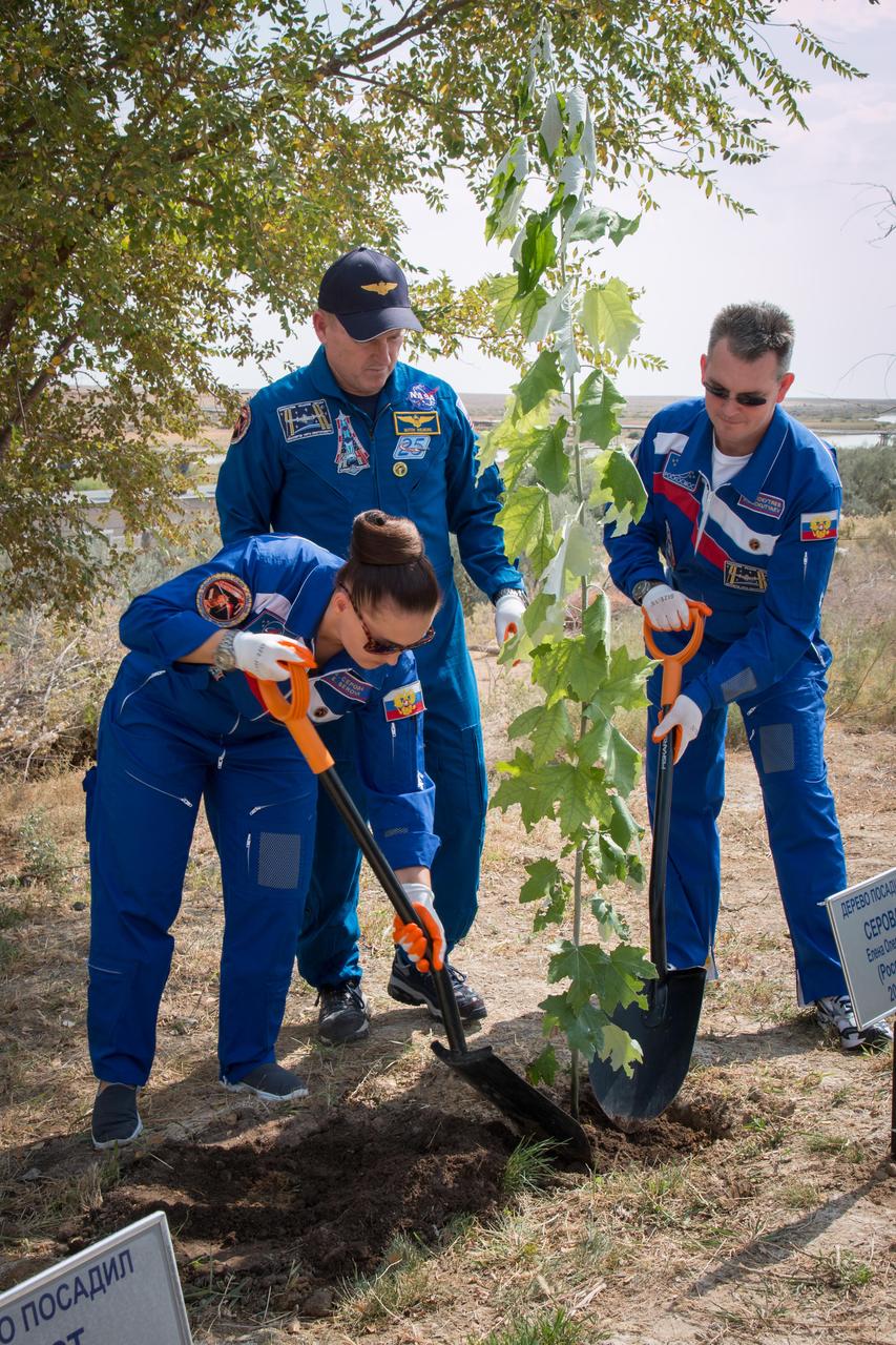 17-14-22-37-4:  (17 Sept. 2014) --- Assisted by NASA Flight Engineer Barry Wilmore (center) and Soyuz Commander Alexander Samokutyaev of the Russian Federal Space Agency (Roscosmos), right, Expedition 41/42 Flight Engineer Elena Serova of Roscosmos (left) plants a tree at a plot bearing her name behind the Cosmonaut Hotel crew quarters in Baikonur, Kazakhstan Sept. 17 during traditional ceremonies. Wilmore, Serova and Samokutyaev are scheduled to launch from the Baikonur Cosmodrome Sept. 26, Kazakh time, in the Soyuz TMA-14M spacecraft for a 5 ½ month mission on the International Space Station. Serova will become the fourth Russian woman to fly in space and the first Russian woman to live and work on the station. Photo credit:  NASA/Victor Zelentsov 