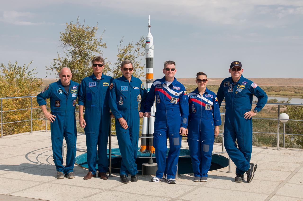 17-14-33-00:  (17 Sept. 2014) --- Behind their Cosmonaut Hotel crew quarters in Baikonur, Kazakhstan, the Expedition 41/42 prime and backup crew members pose for pictures Sept. 17 during a break from their training. From left to right are backup crew members Scott Kelly of NASA, Gennady Padalka of the Russian Federal Space Agency (Roscosmos) and Mikhail Kornienko of Roscosmos and prime crew members Alexander Samokutyaev of Roscosmos, Elena Serova of Roscosmos and Barry Wilmore of NASA. Wilmore, Serova and Samokutyaev are scheduled tol launch from the Baikonur Cosmodrome Sept. 26, Kazakh time, in the Soyuz TMA-14M spacecraft for a 5 ½ month mission on the International Space Station. Serova will become the fourth Russian woman to fly in space and the first Russian woman to live and work on the station. Kelly and Kornienko will launch in March 2015 to spend a full a year on the station.  Photo credit: NASA/Victor Zelentsov 
