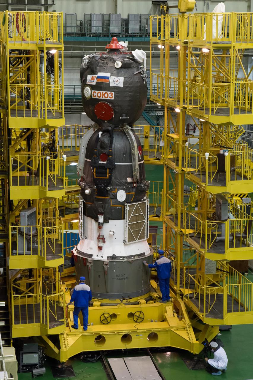 2014-09-18-11-42-24 At the Integration Facility at the Baikonur Cosmodrome in Kazakhstan, the Soyuz TMA-14M spacecraft stands ready for its encapsulation in the upper stage of the Soyuz booster rocket Sept. 18 that will propel it into orbit. The Soyuz will arrive at its launch pad on Sept. 23 for final pre-launch preparations. Expedition 41/42 Flight Engineer Barry Wilmore of NASA, Soyuz Commander Alexander Samokutyaev of the Russian Federal Space Agency (Roscosmos) and Flight Engineer Elena Serova of Roscosmos will launch aboard the Soyuz Sept. 26, Kazakh time, to begin a 5 ½ month mission on the International Space Station. Serova will become the fourth Russian woman to fly in space and the first Russian woman to live and work on the station.  NASA/Victor Zelentsov 