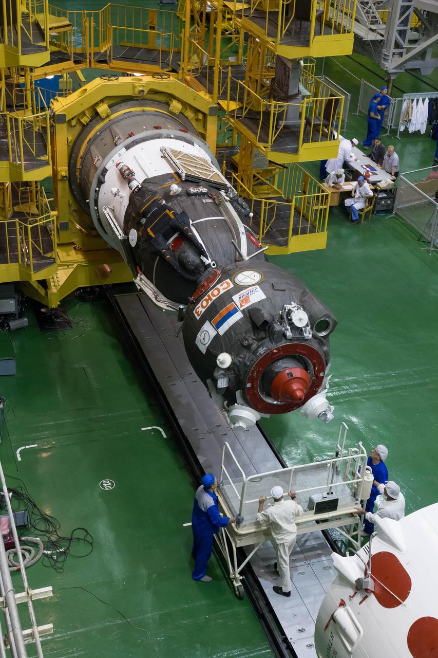 2014-09-18-12-03-22 At the Integration Facility at the Baikonur Cosmodrome in Kazakhstan, the Soyuz TMA-14M spacecraft is rotated to a horizontal position for its encapsulation in the upper stage of the Soyuz booster rocket Sept. 18 that will propel it into orbit. The Soyuz will arrive at its launch pad on Sept. 23 for final pre-launch preparations. Expedition 41/42 Flight Engineer Barry Wilmore of NASA, Soyuz Commander Alexander Samokutyaev of the Russian Federal Space Agency (Roscosmos) and Flight Engineer Elena Serova of Roscosmos will launch aboard the Soyuz Sept. 26, Kazakh time, to begin a 5 ½ month mission on the International Space Station. Serova will become the fourth Russian woman to fly in space and the first Russian woman to live and work on the station.  NASA/Victor Zelentsov 
