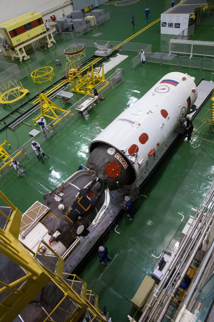2014-09-18-13-19-55 At the Integration Facility at the Baikonur Cosmodrome in Kazakhstan, the Soyuz TMA-14M spacecraft is encapsulated in the upper stage of the Soyuz booster rocket Sept. 18 that will propel it into orbit. The Soyuz will arrive at its launch pad on Sept. 23 for final pre-launch preparations. Expedition 41/42 Flight Engineer Barry Wilmore of NASA, Soyuz Commander Alexander Samokutyaev of the Russian Federal Space Agency (Roscosmos) and Flight Engineer Elena Serova of Roscosmos will launch aboard the Soyuz Sept. 26, Kazakh time, to begin a 5 ½ month mission on the International Space Station. Serova will become the fourth Russian woman to fly in space and the first Russian woman to live and work on the station.  NASA/Victor Zelentsov 