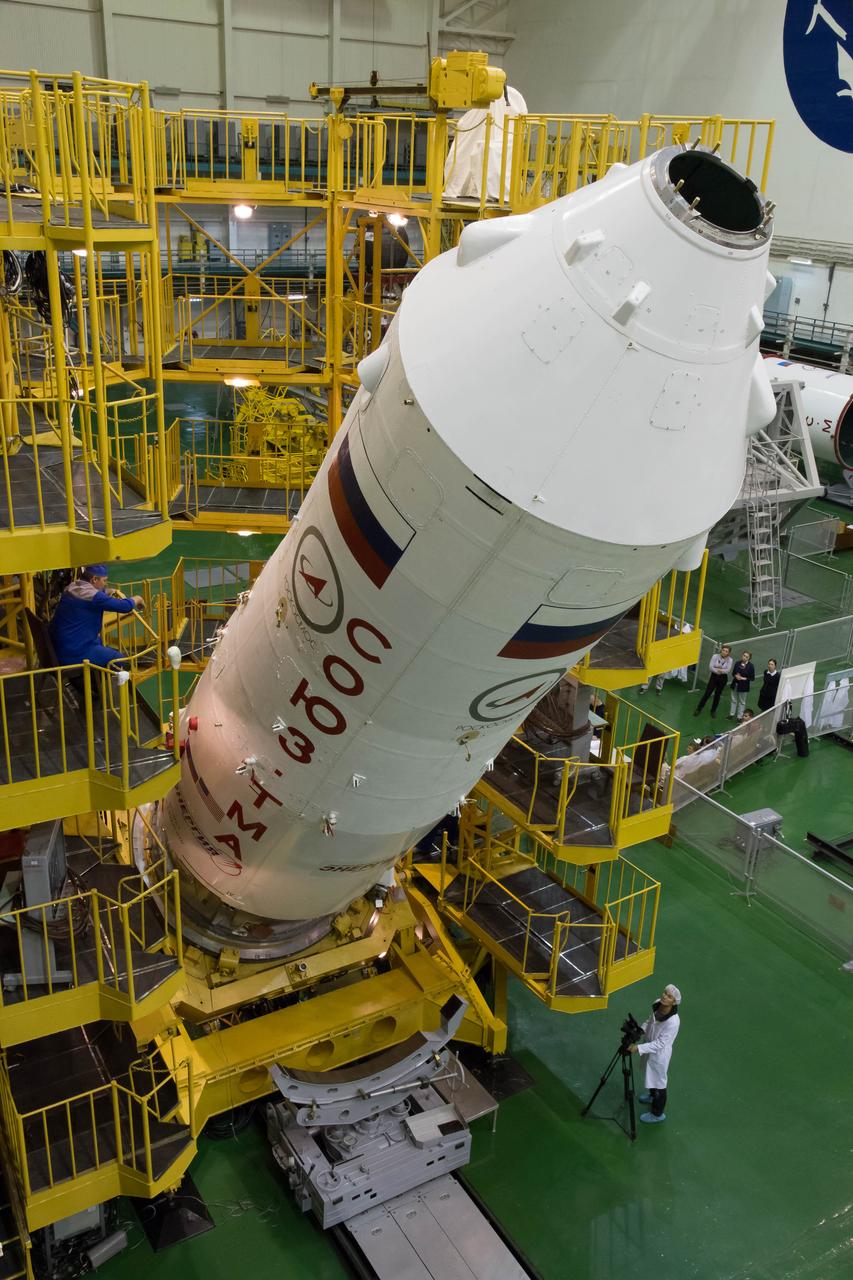 2014-09-18-14-07-33 At the Integration Facility at the Baikonur Cosmodrome in Kazakhstan, the upper stage of the Soyuz booster rocket is raised to a vertical poition after the Soyuz TMA-14M spacecraft was encapsulated inside Sept. 18. The Soyuz will arrive at its launch pad on Sept. 23 for final pre-launch preparations. Expedition 41/42 Flight Engineer Barry Wilmore of NASA, Soyuz Commander Alexander Samokutyaev of the Russian Federal Space Agency (Roscosmos) and Flight Engineer Elena Serova of Roscosmos will launch aboard the Soyuz Sept. 26, Kazakh time, to begin a 5 ½ month mission on the International Space Station. Serova will become the fourth Russian woman to fly in space and the first Russian woman to live and work on the station.  NASA/Victor Zelentsov 