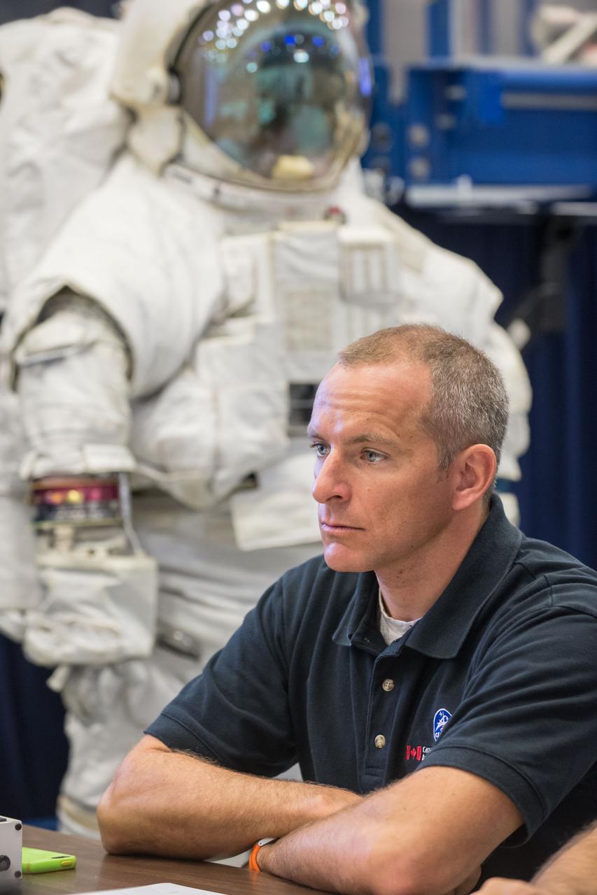 Date: 09-23-14 Location: Bldg 9NW, ISS Airlock Subject: Expedition 48 crew member (Soyuz 46) Jeff Williams during ISS EVA P/P 1 (PRESS w/cooling) training with CSA astronaut Saint Jacques and Expedition 47 crew member Tim Peake in Space Vehicle Mockup Training Facilities (SVMTF) ISS Airlock mockup with instructor Megan Murphey. Photographer: James Blair