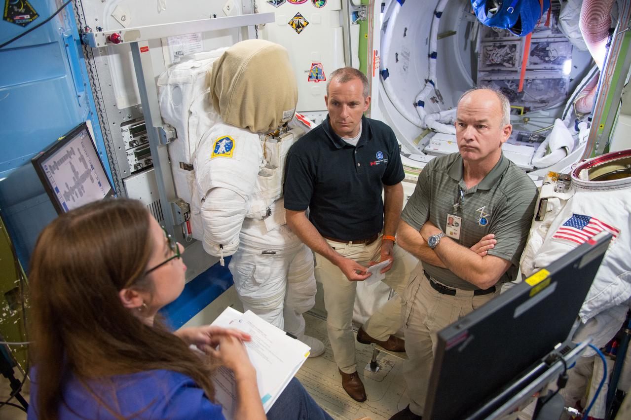 Date: 09-23-14 Location: Bldg 9NW, ISS Airlock Subject: Expedition 48 crew member (Soyuz 46) Jeff Williams during ISS EVA P/P 1 (PRESS w/cooling) training with CSA astronaut Saint Jacques and Expedition 47 crew member Tim Peake in Space Vehicle Mockup Training Facilities (SVMTF) ISS Airlock mockup with instructor Megan Murphey. Photographer: James Blair