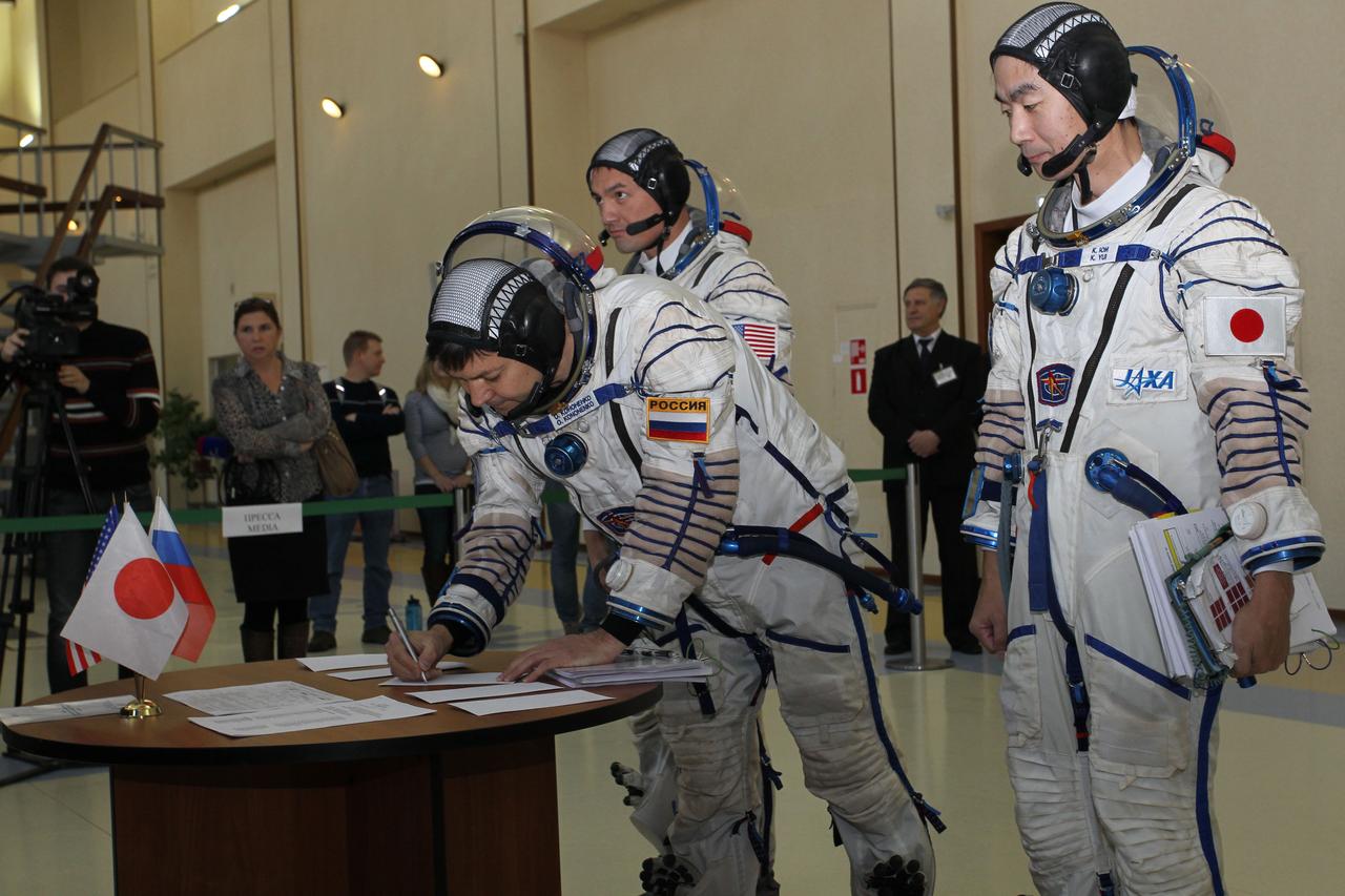 #3186 – (30 October 2014) --- At the Gagarin Cosmonaut Training Center in Star City, Russia, Expedition 42/43 backup Soyuz Commander Oleg Kononenko of Roscosmos signs in for the first of two days of qualification exams October 30 as his crewmates, Kjell Lindgren of NASA (left) and Kimiya Yui of the Japan Aerospace Exploration Agency look on.  They are the backups to the prime crew --- Terry Virts of NASA, Anton Shkaplerov of Roscosmos and Samantha Cristoforetti of the European Space Agency --- who are in the final stages of training for launch November 24, Kazakh time, in the Soyuz TMA-15M spacecraft to begin a five and a half month mission on the International Space Station. Photo credit: NASA/Stephanie Stoll 